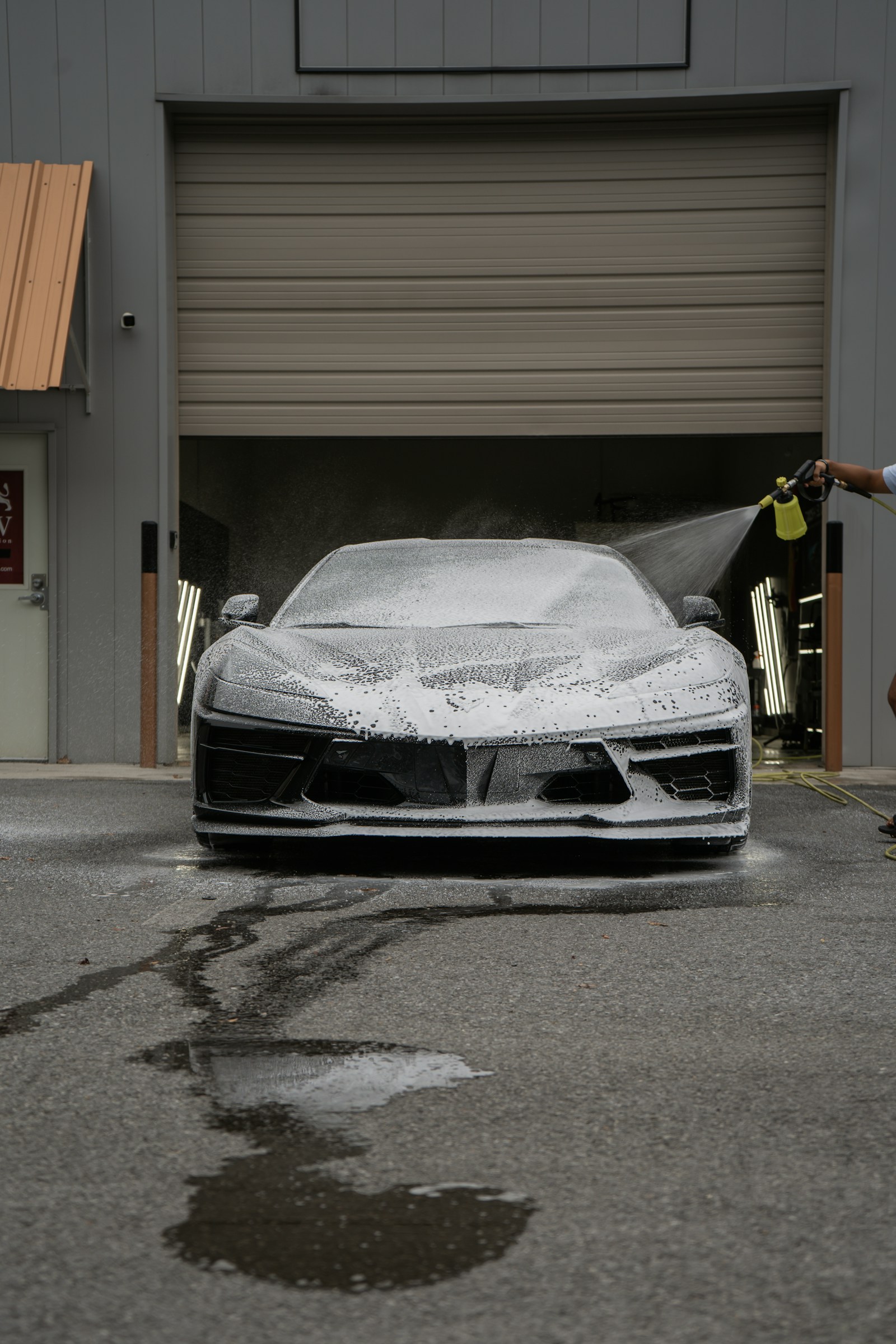 Foam-covered sports car receiving a professional exterior wash